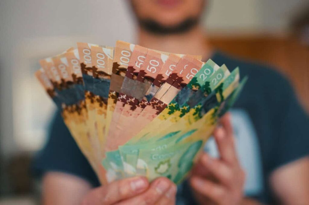 Cash Feels Safe Again: This Is the Expensive Risk Investors Are Missing Man holds Canadian dollars in differing amounts